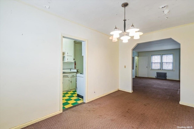 carpeted empty room featuring radiator, an inviting chandelier, and ornamental molding