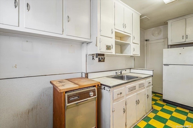 kitchen with stainless steel dishwasher, white fridge, white cabinets, and sink