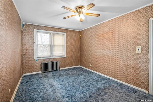 empty room featuring dark colored carpet, radiator, ornamental molding, and ceiling fan