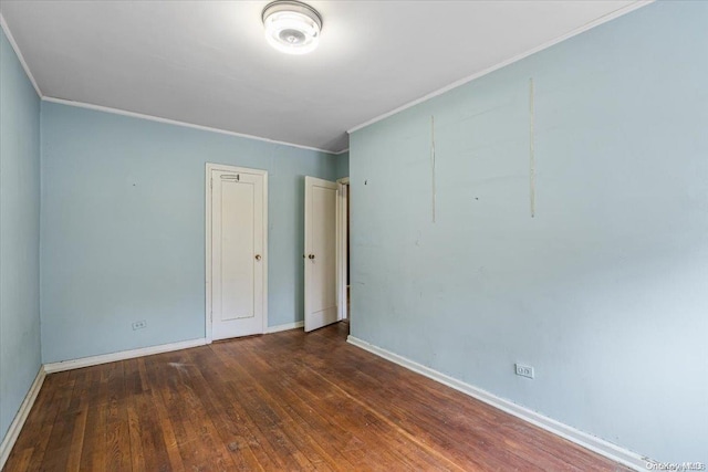 spare room with ornamental molding and dark wood-type flooring