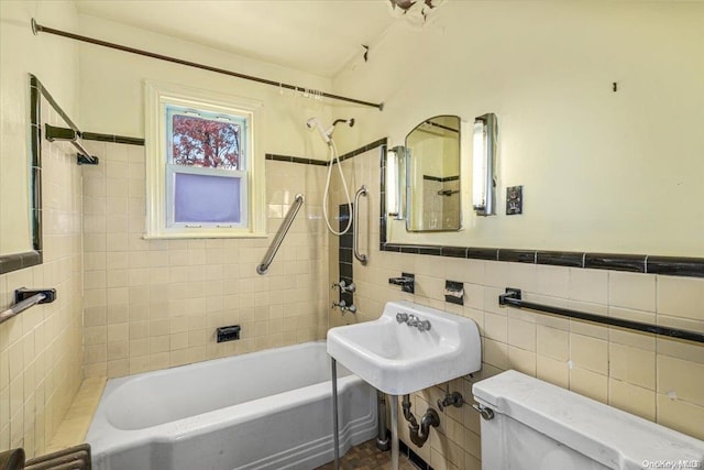 full bathroom with tiled shower / bath, toilet, tile walls, and sink