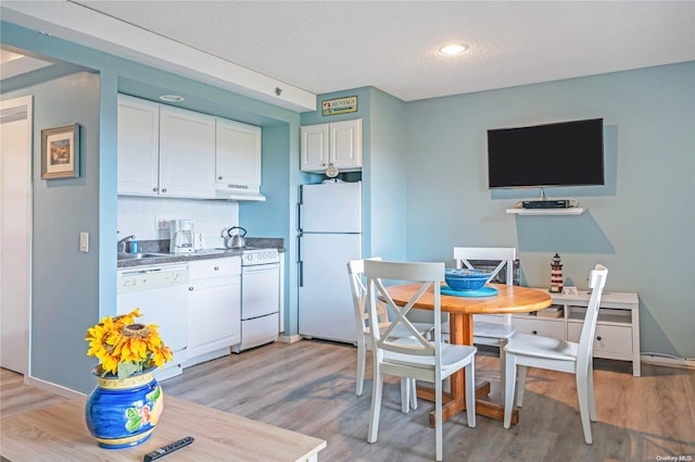 kitchen with light wood-type flooring, white appliances, and white cabinetry