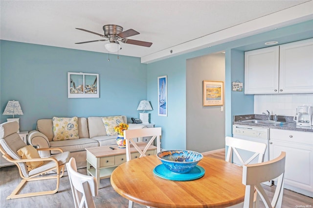 dining room with ceiling fan, sink, track lighting, and light hardwood / wood-style flooring