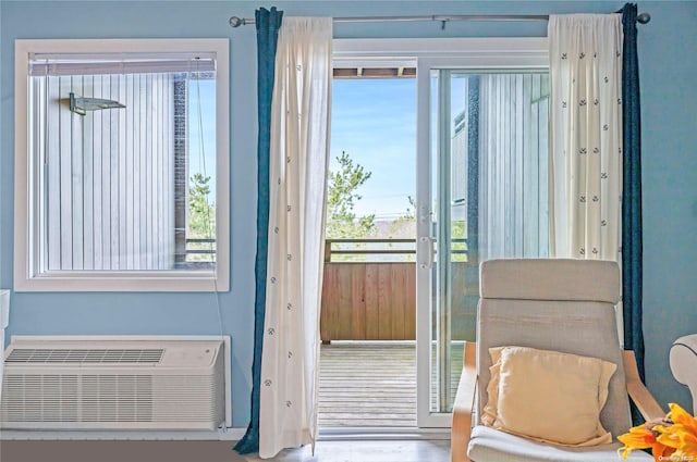 doorway to outside with a wall mounted air conditioner and hardwood / wood-style flooring