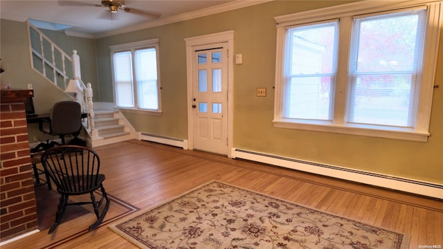 foyer featuring hardwood / wood-style floors, a baseboard radiator, and a healthy amount of sunlight