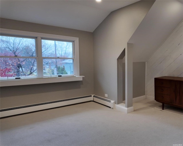 additional living space featuring light carpet, a baseboard radiator, and lofted ceiling