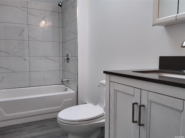 full bathroom with vanity, hardwood / wood-style floors, tiled shower / bath combo, and toilet