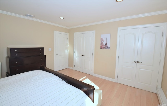1070 Mckinley St, Baldwin, NY 11510 - bedroom featuring two closets, wood finished floors, crown molding, baseboards, and recessed lighting