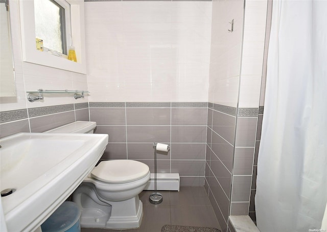 1070 Mckinley St, Baldwin, NY 11510 - full bathroom featuring tile walls, tiled shower, toilet, baseboard heating, and tile patterned floors