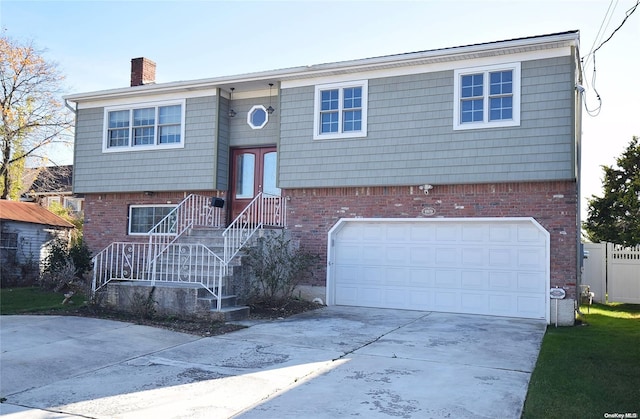 1070 Mckinley St, Baldwin, NY 11510 - split foyer home featuring driveway, a garage, a chimney, and brick siding