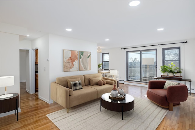 living room with light wood-style floors, baseboard heating, and recessed lighting