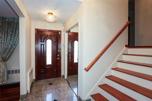 foyer featuring radiator and an inviting chandelier