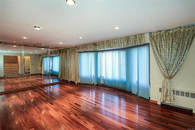 unfurnished room featuring radiator and hardwood / wood-style floors