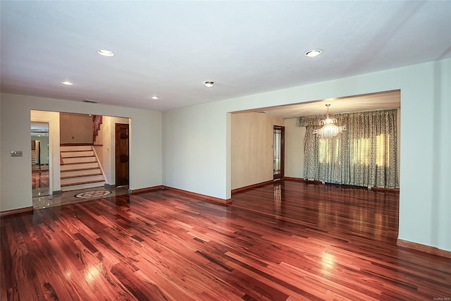 unfurnished room with dark hardwood / wood-style flooring and a notable chandelier