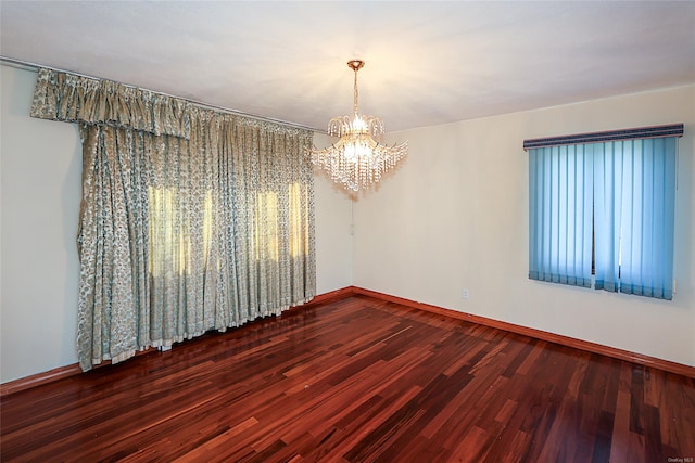 unfurnished room with a chandelier and hardwood / wood-style floors