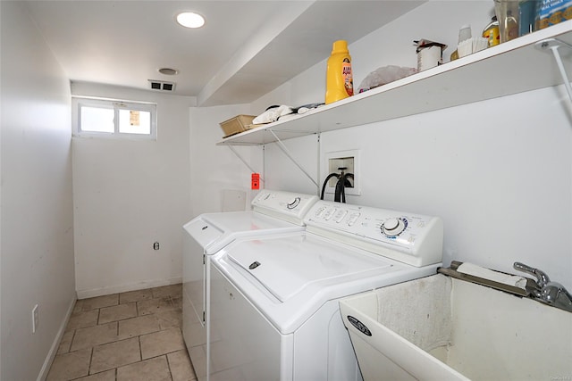 laundry area with light tile patterned flooring, separate washer and dryer, and sink