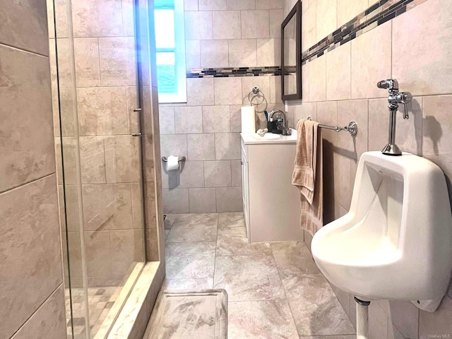 bathroom featuring a shower with shower door and tile walls