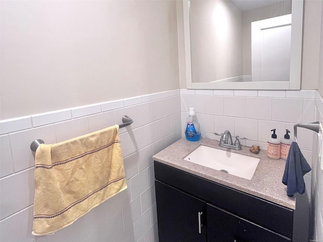 bathroom featuring vanity and tile walls