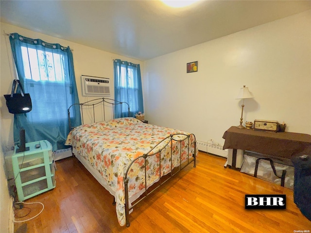 bedroom with hardwood / wood-style flooring, multiple windows, baseboard heating, and a wall unit AC