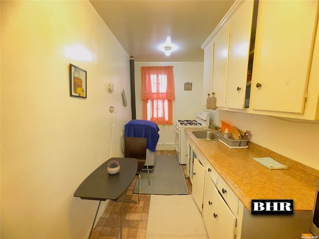 kitchen with white range with gas cooktop and white cabinets