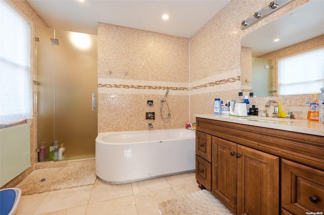 bathroom with tile patterned flooring, vanity, and shower with separate bathtub