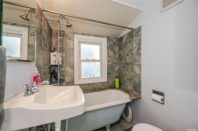 full bathroom with sink, tiled shower / bath, and toilet