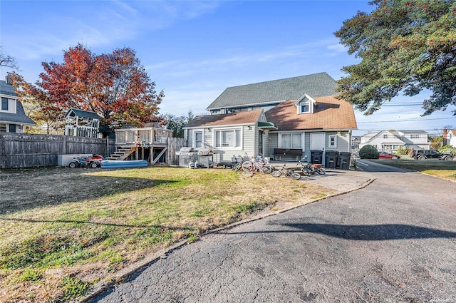 view of front facade featuring a deck and a front lawn