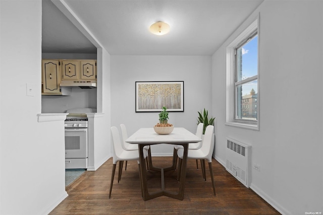 dining room with dark hardwood / wood-style floors and radiator heating unit