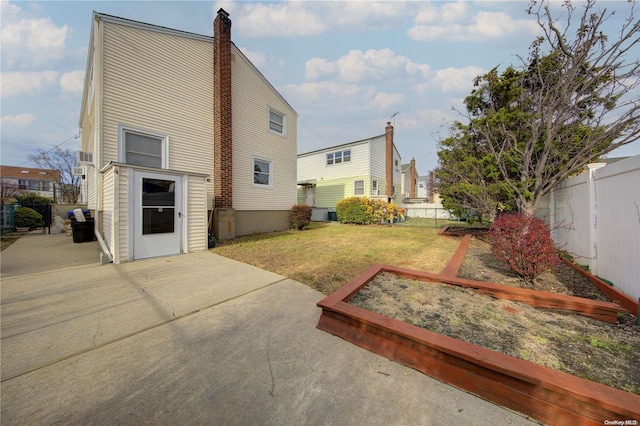 rear view of house featuring a lawn and a patio area