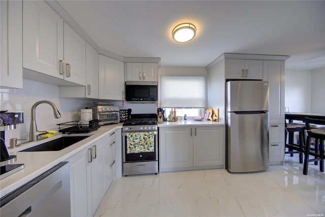 kitchen with backsplash, sink, and appliances with stainless steel finishes