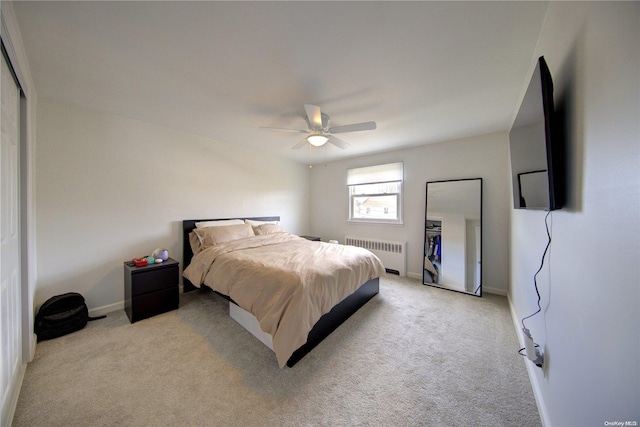 bedroom with light colored carpet, radiator, and ceiling fan