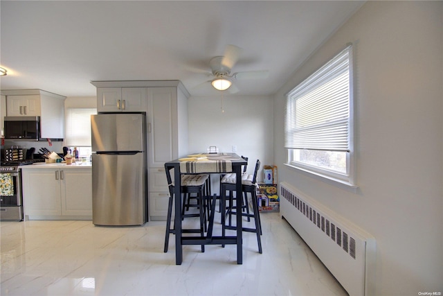 dining space featuring radiator heating unit and ceiling fan