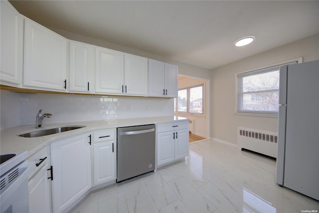 kitchen featuring radiator, white cabinetry, sink, backsplash, and white appliances