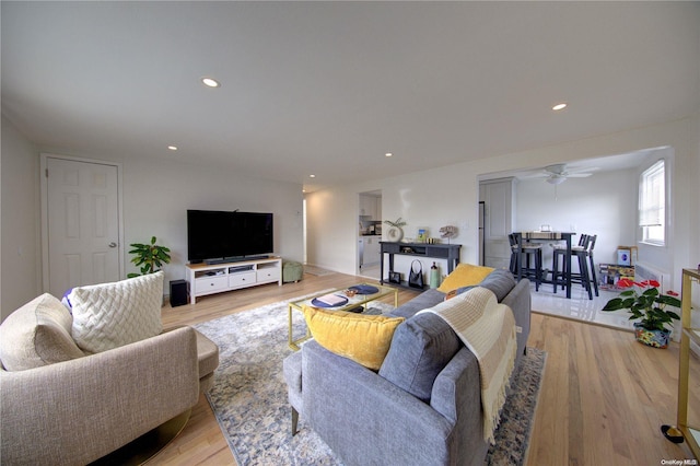 living room with light wood-type flooring and ceiling fan