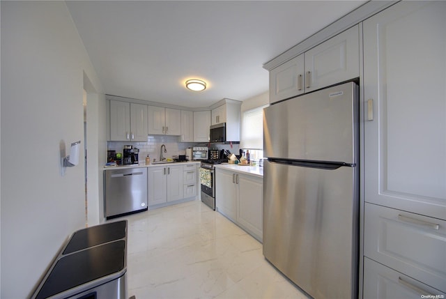 kitchen featuring stainless steel appliances, tasteful backsplash, and sink