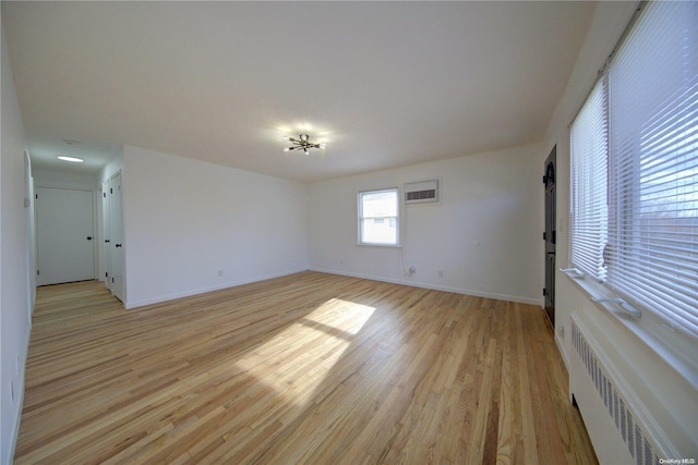 empty room featuring light hardwood / wood-style floors and radiator heating unit