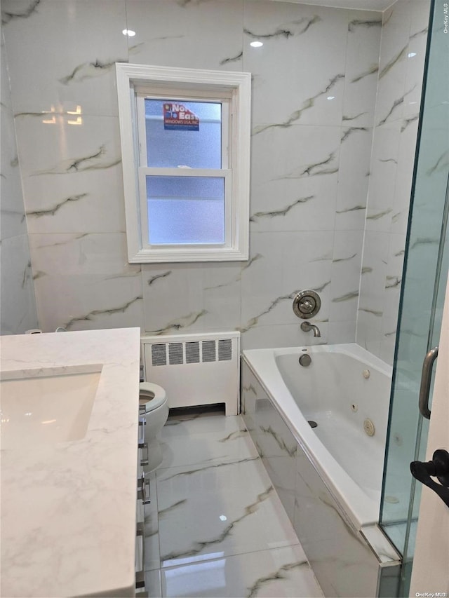 full bathroom featuring tiled shower / bath, radiator heating unit, vanity, and toilet