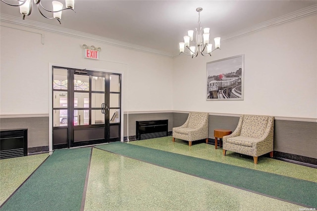 sitting room featuring crown molding, carpet floors, and a notable chandelier