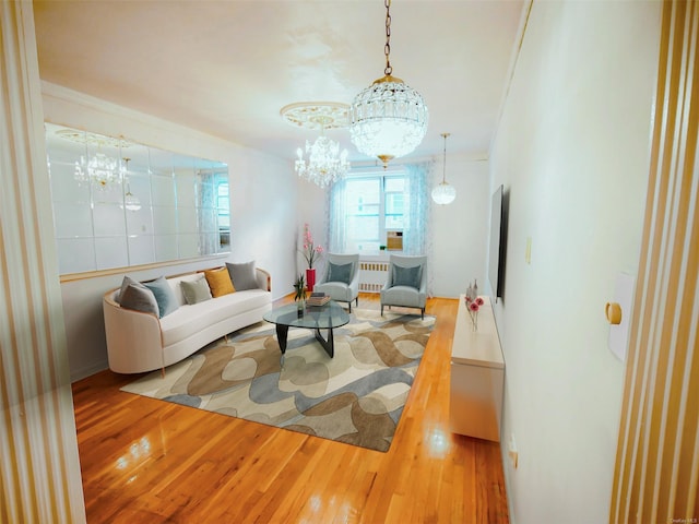 living room with crown molding, radiator heating unit, a chandelier, and wood-type flooring