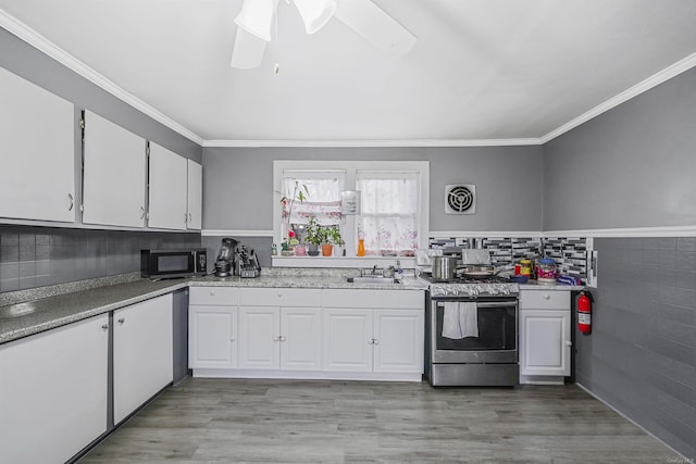 kitchen with sink, light wood-type flooring, white cabinetry, and stainless steel electric range