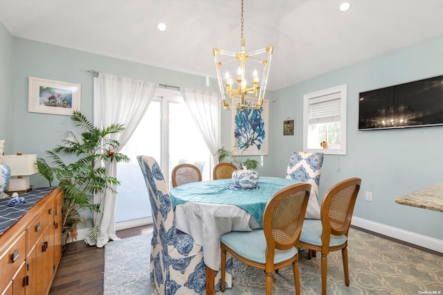 dining space featuring lofted ceiling, dark hardwood / wood-style floors, and a notable chandelier