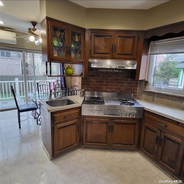 kitchen with backsplash, ceiling fan, extractor fan, and stainless steel gas stovetop