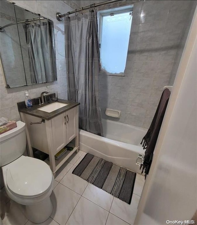 full bathroom with tile patterned flooring, vanity, tile walls, and shower / bath combo with shower curtain