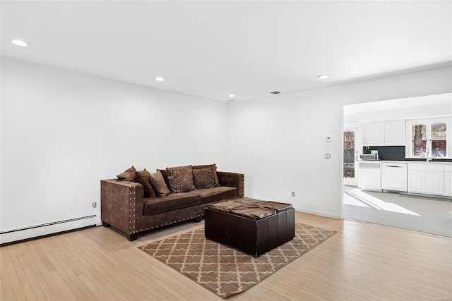 living room featuring light hardwood / wood-style flooring and a baseboard heating unit