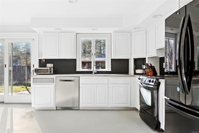 kitchen with black appliances, plenty of natural light, and white cabinets