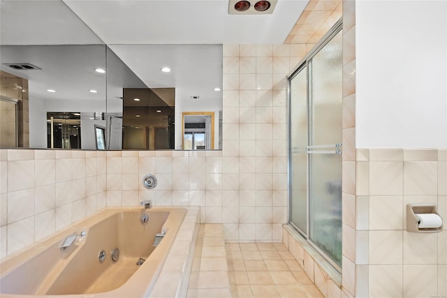 bathroom featuring tile walls and independent shower and bath