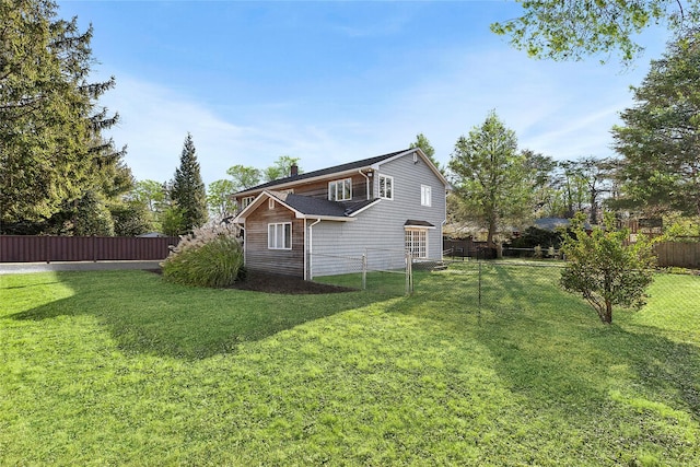 rear view of house featuring a yard