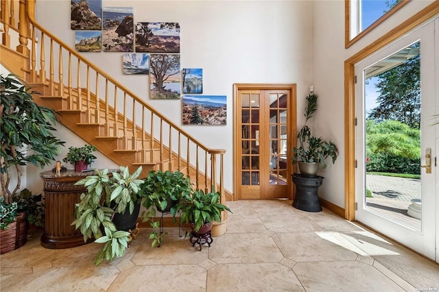 foyer entrance with a towering ceiling and french doors