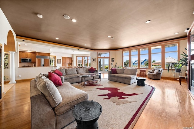 living room with ornate columns and light hardwood / wood-style flooring