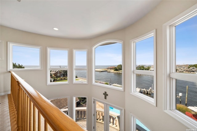 corridor featuring plenty of natural light and a water view